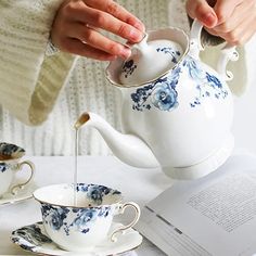 a woman pours tea into a blue and white porcelain teapot with saucer