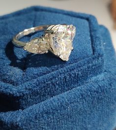 a diamond ring sitting on top of a blue cloth