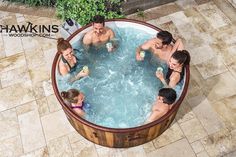 four people are in the hot tub with drinks