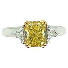 Ring, French Engagement Yellow Diamond Surrounded, Two Diamond, White Gold Color appears consistent with Fancy Yellow A magnificent ring in 18 carat white gold with a timeless elegance. This exceptional piece weighs 5.5 grams, giving it a luxurious and solid feel when worn. The real focal point of this ring is the centre of the ring, where a "Radian" cut yellow diamond lies. At 1.53 carats, this diamond captures attention with its unparalleled brilliance and sparkle. Measuring 8 mm x 8 mm, it of Yellow Platinum Diamond Ring Fine Jewelry, Fine Jewelry Yellow Diamond Platinum Ring, Yellow Diamond Cut Platinum Ring, Yellow Platinum Diamond Ring With Diamond Cut, Yellow Platinum Diamond Ring, Elegant Yellow Emerald-cut Diamond Ring, Elegant Yellow Emerald Cut Diamond Ring, Platinum Rings With Yellow Diamond Accents, Yellow Platinum Rings With Diamond Accents