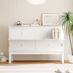 a living room with a white dresser and a potted plant