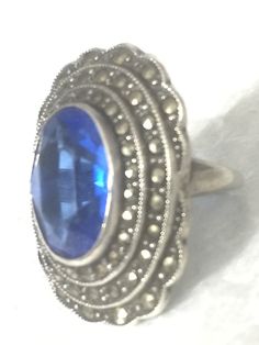 "Art Deco Vintage Blue Glass Stone & Marcasites Sterling Silver Ring Size 3.25 Weight 6.7g Length 1 1/16\" Width 3/4\" Rings are delivered in a Gift Box Free Domestic USA Shipping & Free Postal Insurance If you do not want the ring polished and want to leave the natural patina please let me know at the time of purchase as I do polish rings before I ship rings out. Thanks USPS Domestic Shipping is free for buyers. If a buyer prefers to upgrade to priority, the buyer will pay that portion Vintage Blue Oval Cluster Ring, Vintage Blue Sapphire Round Ring, Antique Blue Cluster Ring, Vintage Blue Gemstone Cluster Ring, Blue Gemstone Cluster Ring Vintage Style, Collectible Blue Gemstone Ring, Antique Blue Sapphire Ring Collectible, Antique Blue Sapphire Collectible Ring, Vintage Blue Hallmarked Cluster Ring