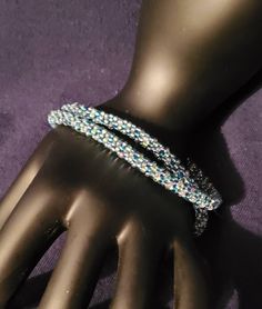 This beautiful 8 strand double wrap woven bracelet is made with 4 colors of seed beads: blue, light green, pink and light purple. A silver magnetic locking clasp finishes off this beautiful piece of jewelry. Wrist size 7. Blue Beaded Multi-strand Wrap Bracelet, Handmade Blue Double Strand Beaded Bracelets, Handmade Silver Multi-strand Wrap Bracelet, Handmade Multi-strand Party Bracelets, Silver Beaded Multi-strand Wrap Bracelet, Handmade Double Strand Silver Beaded Bracelets, Silver Multi-strand Beaded Wrap Bracelet, Handmade Silver Double Strand Beaded Bracelets, Elegant Handmade Blue Wrap Bracelet