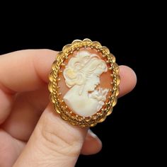 "Mid-century 14K gold cameo brooch. Circa 1960's. Genuine shell cameo set in a heavy 14K gold setting. 1.25\" inches long, 1.1\" inches wide. Marked on the pin stem. Depicts a beautiful young woman wearing long earrings and a dress with a large bow on her shoulder. The brooch is in excellent condition. Could be converted to a pendant. A rare find.  A stunning gift for that special someone. Pleasee contact me if you have any questions." Cameo Round Brooch Collectible, Vintage Cameo Brooch In Yellow Gold, Vintage Yellow Gold Cameo Brooch, Gold Cameo Brooch Collectible, Vintage Yellow Gold Oval Brooch, Retro Gold Cameo Jewelry, Vintage Oval Gold Brooches, Retro Cameo Jewelry For Formal Occasions, Antique Jewelry Necklace