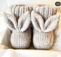 two knitted baby booties in a white box