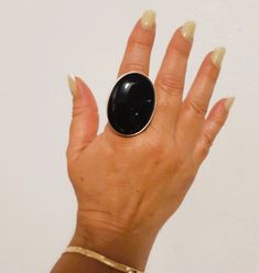 "This ring is pecfect as statement  because the larger Black gemstone  is 40 x 30 mm, the band is 8 mm width and 1 mm thickness Fine Silver. \"onyx,  has a slow, grounding and stable frequency to it. It is a gem that took its time in being formed. The gift of black onyx is the energy of strong support, stamina and determination to help one persevere. It will teach the wearer to rely on his or her own powers and trust their inner voice.\" *This  jewel will be sent to you in a beautiful gift box * Black Round Jewelry With Large Stone, Black Jewelry With Large Round Stone, Modern Black Adjustable Rings, Black Rings With Large Stone For Gift, Black Onyx Jewelry With Large Stone, Black Ring With Large Stone For Gift, Modern Onyx Ring Gift, Adjustable Onyx Rings With Black Enamel, Luxury Onyx Rings With Polished Finish