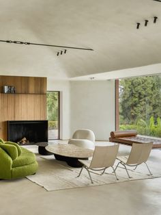 a living room filled with furniture and a fire place next to a large glass window