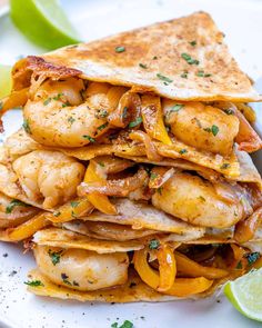 a stack of quesadillas stacked on top of each other with lime wedges