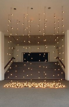 an empty room with stairs and lights hanging from the ceiling over it's carpeted floor