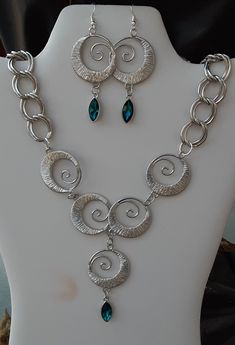 This is a unique classy set. You get both the necklace and earrings. Just choose if you want pierced or clip on earrings. Made with silver tone materials. The necklace is 18 inches long with a 2 inch extender. The middle swirl hangs down about 2 inches, pic above. Please know how this will lay on you before you order. The necklace is heavy, the earrings may be heavy for some.  Be sure to look at my other items too! Affordable Statement Necklace With Matching Earrings, Costume Jewelry Sets With Metal Dangle, Silver Jewelry Sets With Matching Earrings, Metal Costume Jewelry Set With Matching Earrings, Costume Jewelry Multi-strand Necklace For Gifts, Bohemian Jewelry Sets With Matching Earrings, Adjustable, Necklace Earring Set, Unique Necklaces, Clip On Earrings