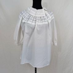 White shirt with balloon sleeves ABOUT | Vintage cottagecore style blouse, with wide collar with pleated workmanship that continues in the upper part of the shirt. Asymmetric buttoning on the shoulder. Big balloon sleeves. The shirt is in white cotton and is a vintage 70s garment. CONDITIONS | Good, a slight halo. It has no size label SIZE & MEASUREMENTS | dresses M shoulders 44 cm sleeve cm 36 length 64 cm TIPS | Red is a flattering color and is easy to match. In spring the red-blue combination Peasant Cotton Blouse For Gatherings, Peasant Style Cotton Blouse For Gatherings, White Summer Blouse For Gatherings, Summer White Blouse For Gatherings, White Blouse For Summer Gatherings, Elegant Cotton Blouse With Gathered Sleeves, White Bishop Sleeve Puff Top With Gathered Sleeves, White Cotton Blouse For Gatherings, Workwear Puff Sleeve Blouse With Smock Detail