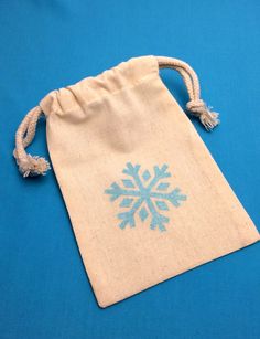 a small bag with a snowflake design on the front and side, sitting on a blue surface