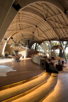 the inside of a building with wooden floors and curved walls, lit up by lights