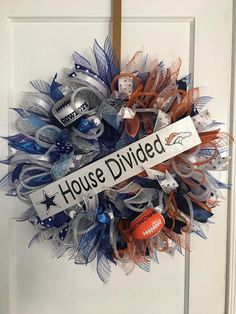 a football wreath is hanging on the front door with a house divided sign attached to it