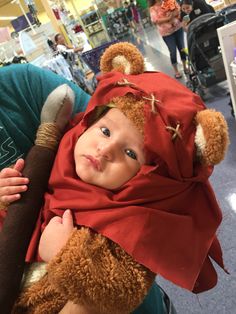 a woman holding a baby wearing a bear costume