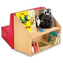 a stuffed animal sitting on top of a wooden book shelf next to a pile of books