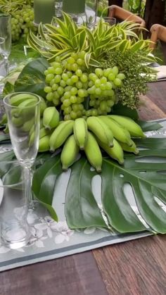 the table is set with green grapes and greenery for an elegant dinner or party