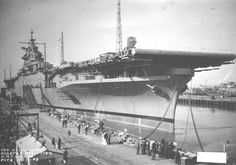 an old photo of a large ship docked in the water with many people around it