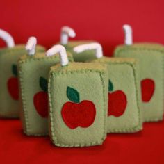 four little apples are sitting on top of each other with white pins in the middle