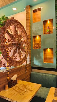 a restaurant with wooden tables and green booths in front of a large clock on the wall