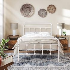 a white bed sitting on top of a wooden floor next to two lamps and a rug