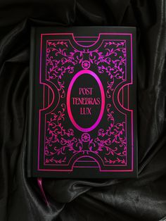 a pink book sitting on top of a black cloth covered tablecloth with the title post teneras luxury