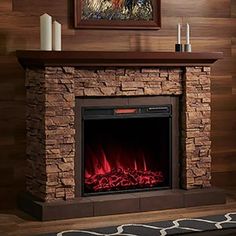 a fire place in a living room with a painting on the wall above it and candles