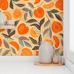 an orange and blue wallpaper in a kitchen with white counter tops, two vases on