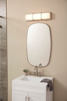 a bathroom sink with a mirror above it and a towel on the counter next to it