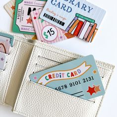 three credit cards are in the pocket of a white card holder, and there is also an empty wallet