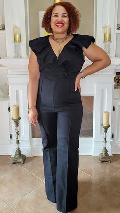 A denim jumpsuit featuring square neckline with front V cut out, ruffle over shoulder to back, bell bottom and back zipper closure - Great Stretch - Back Zipper - Flare Leg - Model Wearing SIze 1X Fitted V-neck Jumpsuit With Ruffles, Black V-neck Jumpsuit With Ruffles, Fitted Wide Leg Overalls For Workwear, Chic Wide Leg Overalls For Work, Chic High Waist Overalls For Work, Formal Black Ruffled Jumpsuits And Rompers, Ruffled V-neck Jumpsuit For Date Night, V-neck Ruffled Jumpsuit For Date Night, Fitted Sleeveless Denim Jumpsuit For Work