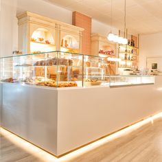 a bakery filled with lots of pastries on display in front of a counter top