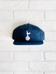 "Vintage Tottenham Hotspur FC Hat - (New) Cotton Unstructured 6 Panel Snapback in Navy Closure - 7 Button Plastic Snap Color - Navy Construction - 6 Panel Snapback Contents - 60% Cotton / 40% Polyester Profile - 3.25\" Size - One Size Fits All (6 ⅝\" - 7 ⅝\") Structure - Lightly Structured - Flocked Tottenham Patch" Vintage Tottenham, Nyc Hat, Chicago Cubs World Series, Ny Hat, Dodger Hats, Chicago Gifts, Vintage Soccer, Cubs Hat, Gold Art Print