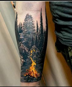 a man's arm with a fire and trees on it