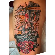 a tattoo with a lighthouse and roses on it