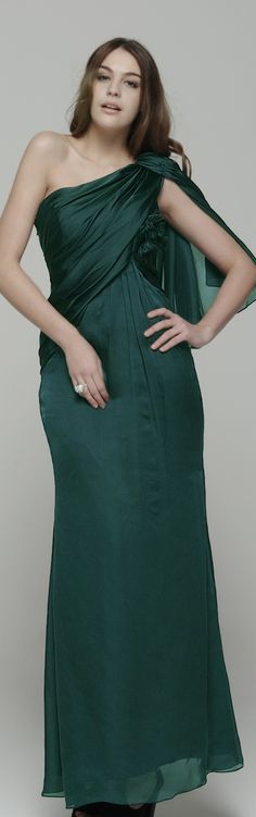 a woman in a green dress posing with her hands on her hips