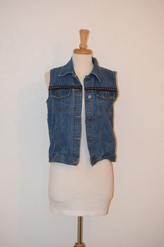 "Retro at its 90's best for popping over your sundress or pairing with your vintage 501 cutoffs. Old school washed / faded denim vest by 'Cherokee' sports hip length styling and fun mini floral embroidered trim.  Laundered and ready to wear.  Free of rips, stains and odor. Women's Small Back of neck to bottom of vest:  23\" Shoulder to shoulder at back:  15\" Under arm seam:  13\" Armpit to armpit:  19\" Side to side at bottom:  19\" For a variety of vintage goodies, check out my shop @: https://www.etsy.com/shop/RagandBonesFinds For a unique pillow fashioned from my treasure trove of vintage fabrics, visit my shop @: https://www.etsy.com/shop/VintagePulledThreads" Festival Vest, Vintage 501, Unique Pillow, Style Vest, 90s Denim, Embroidered Trim, Unique Pillows, Faded Denim, Vest Outfits