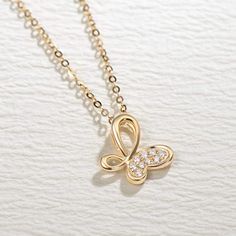 Inspired by infinity and butterfly symbols, this gold ribbon elegantly embrace brilliant diamonds and creates a sophisticated look. Made with 18k solid real yellow gold and diamond. Dimension: 11.6 mm x 12 mm Chain Length: 16"+2" Minimum Total Carat Weight﻿: 0.065 cttw Origin: Imported Fine Jewelry Diamond Butterfly Necklace In Yellow Gold, Diamond Butterfly Necklace In Yellow Gold, Yellow Gold Diamond Butterfly Necklace, Infinity Diamond Necklace In Yellow Gold, Elegant 14k Gold Butterfly Pendant Necklace, Yellow Gold Infinity Diamond Necklace, Elegant Butterfly Necklace With Cubic Zirconia, Elegant Yellow Gold Butterfly Jewelry, Gold Diamond Butterfly Jewelry