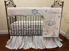 a baby crib with white and blue bedding