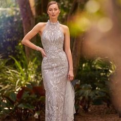 a woman in a silver dress posing for the camera with her hands on her hips