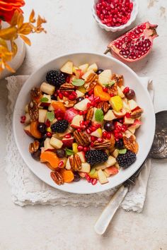 a white bowl filled with fruit and nuts