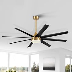 a ceiling fan with black blades in a white living room, next to a large window