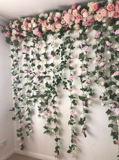 purple and white flowers hanging from the side of a wall