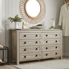 a dresser with drawers and a mirror above it