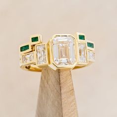 Product Details Ring Style: The Greta" is an art deco-style bezel set moissanite women's engagement ring with moissanite accent stones and a malachite stacking band. Many other center stone options are available upon request. Center Stone: 8x6mm Emerald Cut Moissanite Materials: 14K white gold engagement ring featuring 3 main moissanite stones, baguette moissanite side stones, and a malachite inlay tracer. Customizable: Because each ring is handcrafted to order, we can customize yours using unique materials, gemstones, or design features, often without any added cost! We can even use personal materials that you send! Basic customizations, such as material swaps, can be accommodated by simply adding a request in the “Custom Requests” section during checkout. For more extensive customization Unique Bezel Set Engagement Ring, Art Deco Emerald Engagement Ring, Wedding Band For Emerald Cut Ring, Brand Identity Jewelry, Non Traditional Wedding Ring, Emerald Cut Moissanite Engagement Ring, Emerald Wedding Band, Bezel Set Engagement Ring, Art Deco Wedding Band