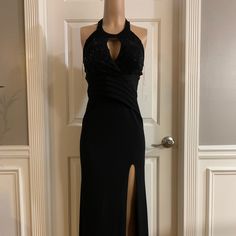 a black dress on display in front of a door with a mannequin's head