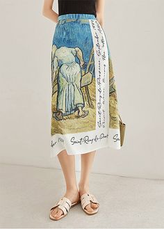 a woman standing in front of a white wall wearing a skirt with an elephant on it