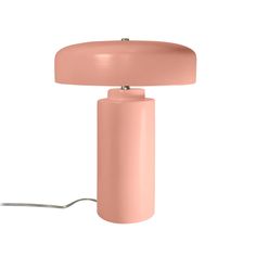 a pink table lamp sitting on top of a white floor next to a light bulb