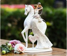 a figurine of a bride and groom riding a horse