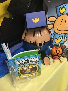 a table topped with books and toys on top of a yellow cloth covered tablecloth